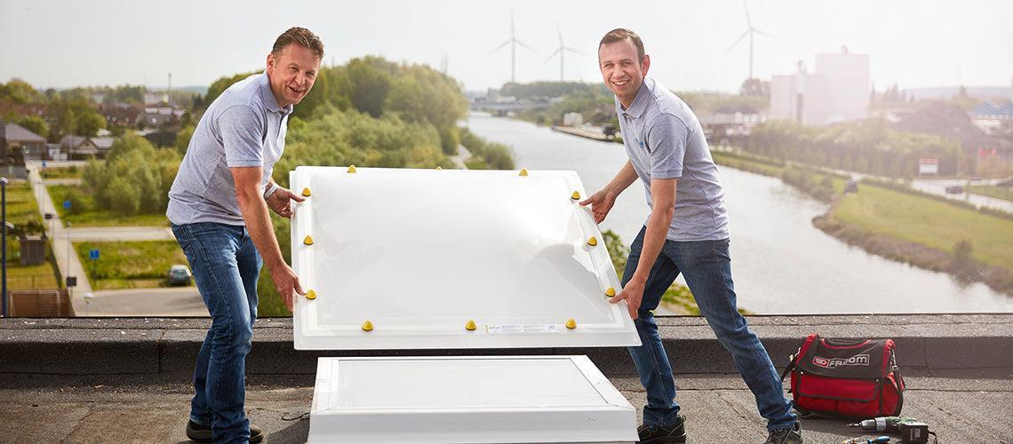 Twee Skylux-professionals plaatsen een platdakraam op een renovatieproject in België