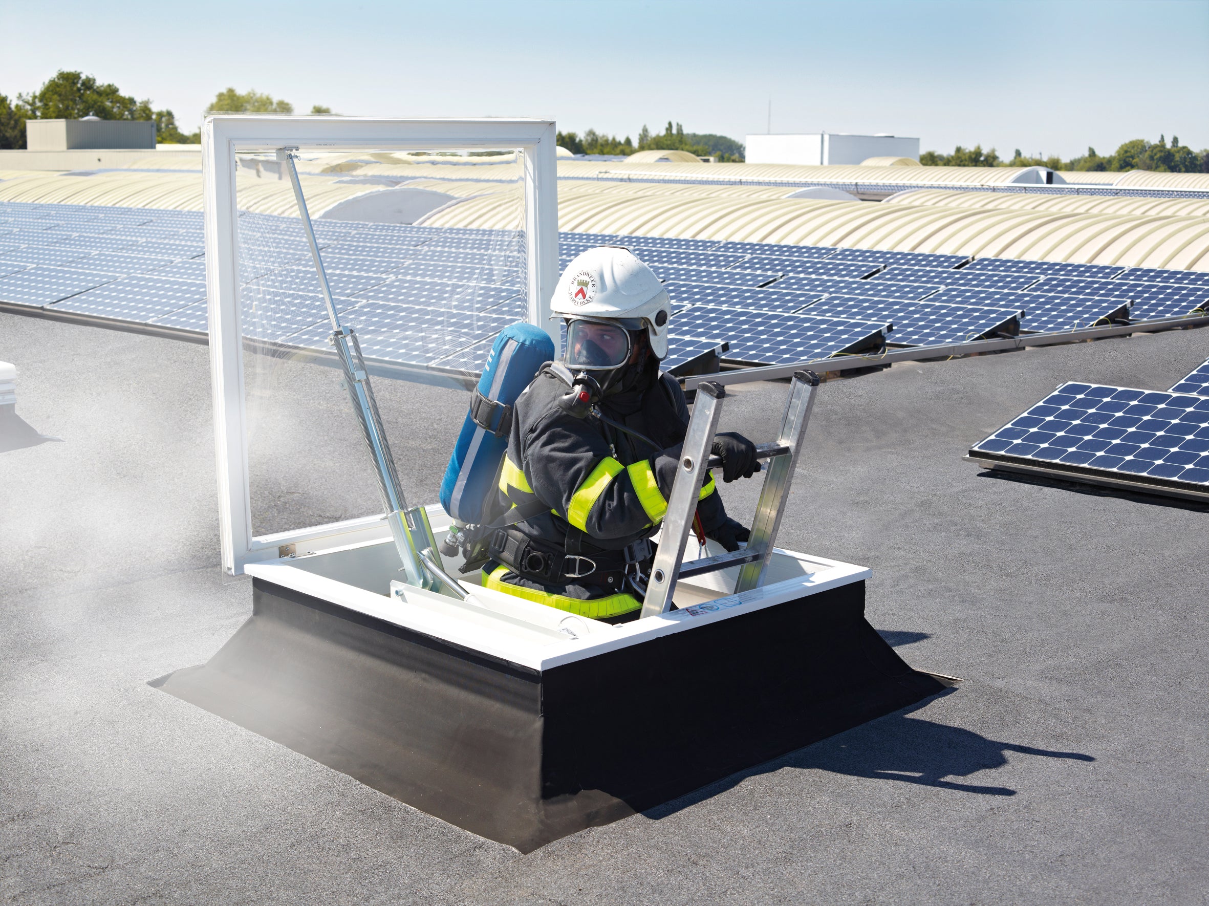 Brandweerman bedient RWA-systeem op dak via prioritaire schakelaar